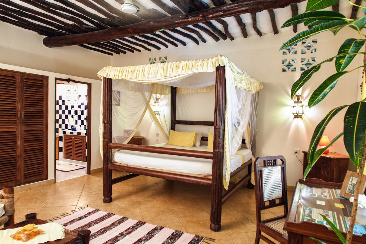 Four-poster bedroom with soft yellow accents