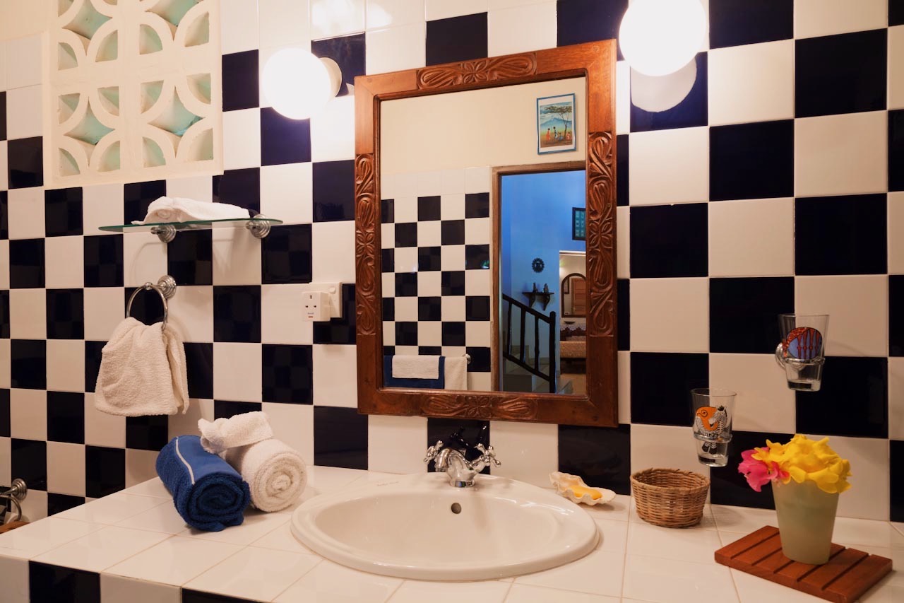 Checkerboard-tiled bathroom with carved mirror