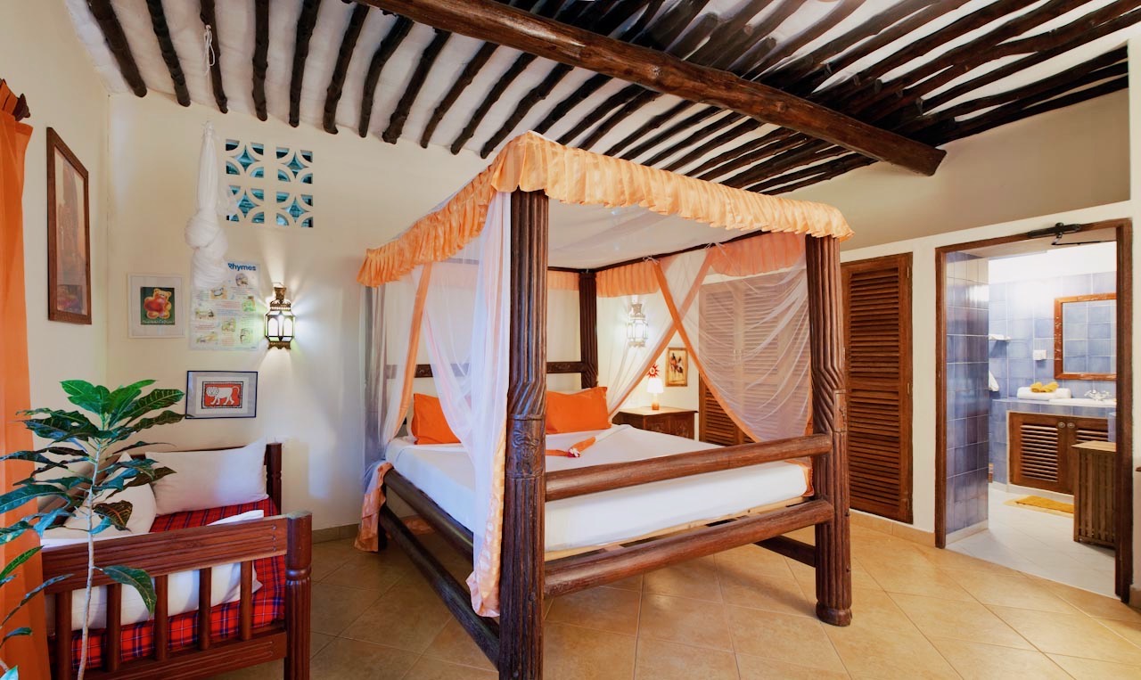 Four-poster bedroom with orange drapes and en-suite